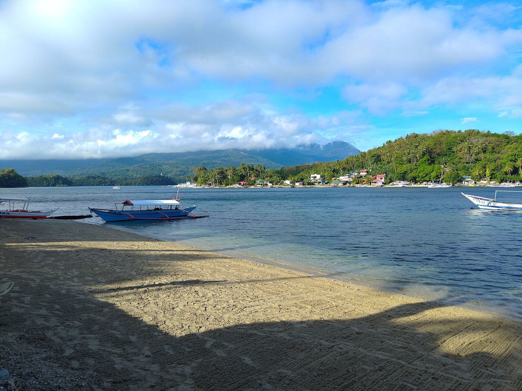 Puerto Galera Bay seen from the hills above, with boats moored in turquoise water